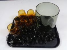A tray containing 20th century coloured glass mugs and brandy glasses.