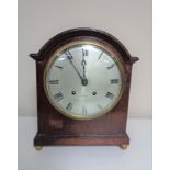 An Edwardian bracket clock with silver dial by Whittaker of Oldham on raised brass feet.