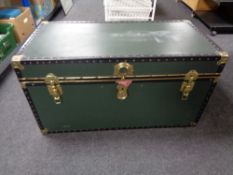 A metal bound shipping trunk containing curtains, bedding, etc (green).