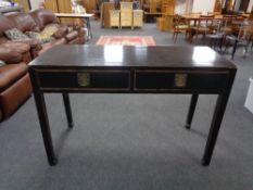 A Chinese style lacquered elm two drawer hall table, width 136 cm.