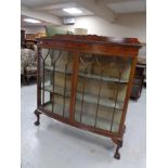 An Edwardian mahogany double door display cabinet on claw and ball feet