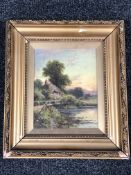 An antique gilt framed oil on board depicting a figure on a bridge with cottage beyond, signed H.