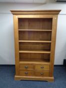 A set of contemporary oak open bookshelves fitted with four drawers.