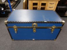 A metal bound shipping trunk containing blankets, bedding, etc (blue).