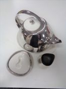 A Georg Jensen three piece tea service comprising teapot with ceramic lid on ceramic stand,