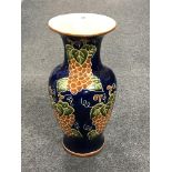 A large glazed pottery vase of grape leaf design.