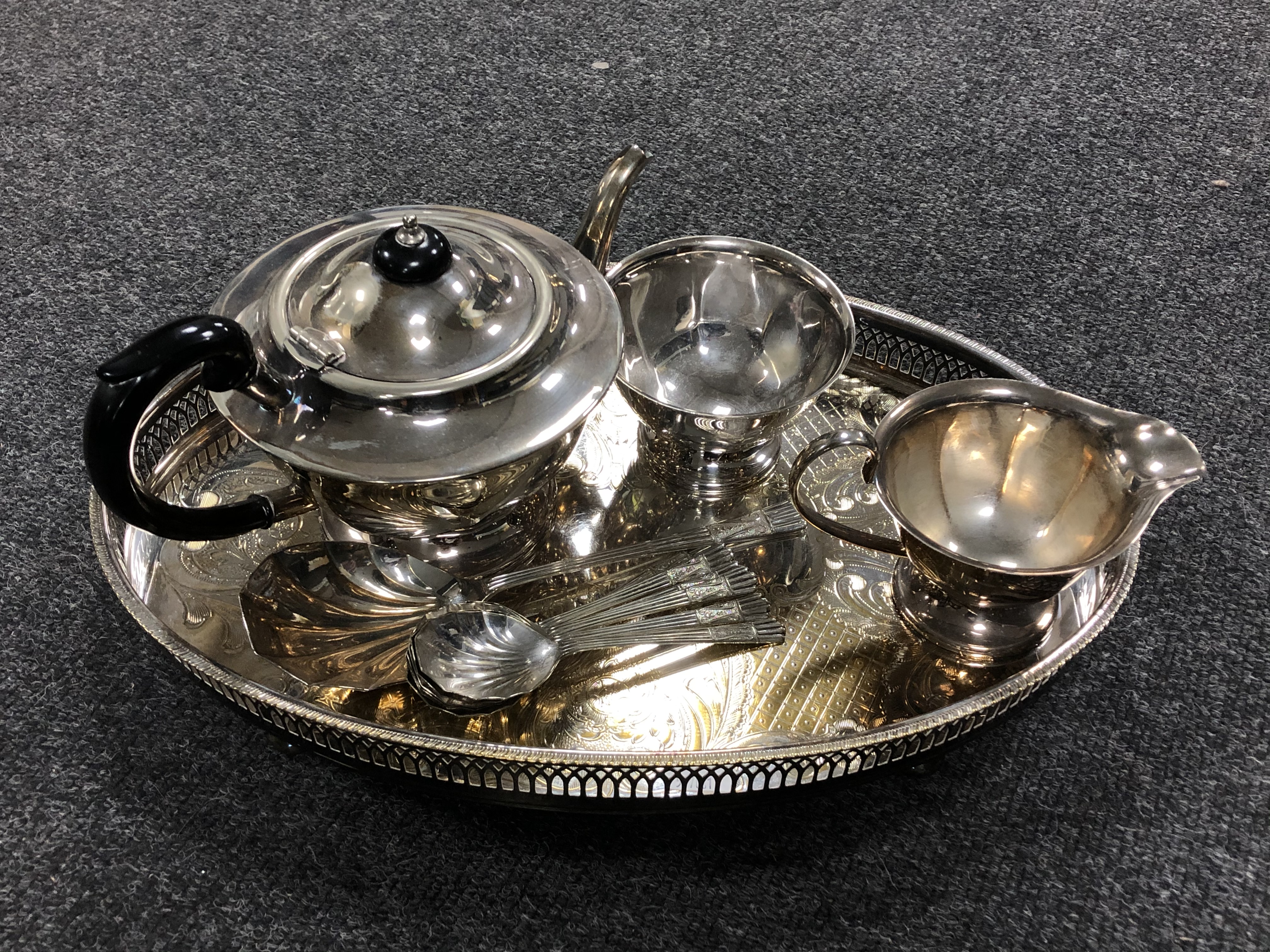 A silver plated gallery tray on raised feet together with a three piece Sheffield Plate tea service