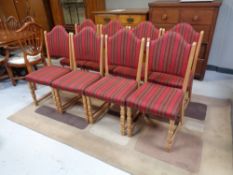 A set of eight continental blond oak dining chairs upholstered in a red striped fabric