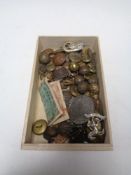 A box containing a collection of military badges and buttons, Edward VII coronation medal etc.