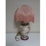 A floral pottery table lamp with shade.