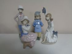 Four Nao figures of girls and boys with dogs