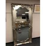 A shaped mirror in silvered swept frame