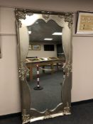 A shaped mirror in silvered swept frame