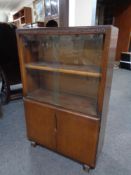 A mid 20th century sliding glass door bookcase, fitted cupboards beneath.