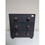 A contemporary six drawer chest with pine knob handles.