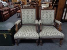 A pair of carved Edwardian armchairs upholstered in a classical brocade fabric.