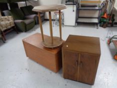 A walnut double door record cabinet together with a teak effect blanket box and an occasional table