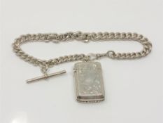 A silver vesta case mounted on heavy silver chain with T-bar.