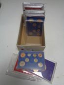 A box containing assorted coin sets and coin cases to include silver wedding,