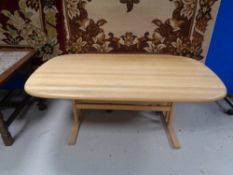 A large oval pine coffee table with under stretcher
