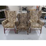 A pair of wingback fireside chairs upholstered in a floral fabric,