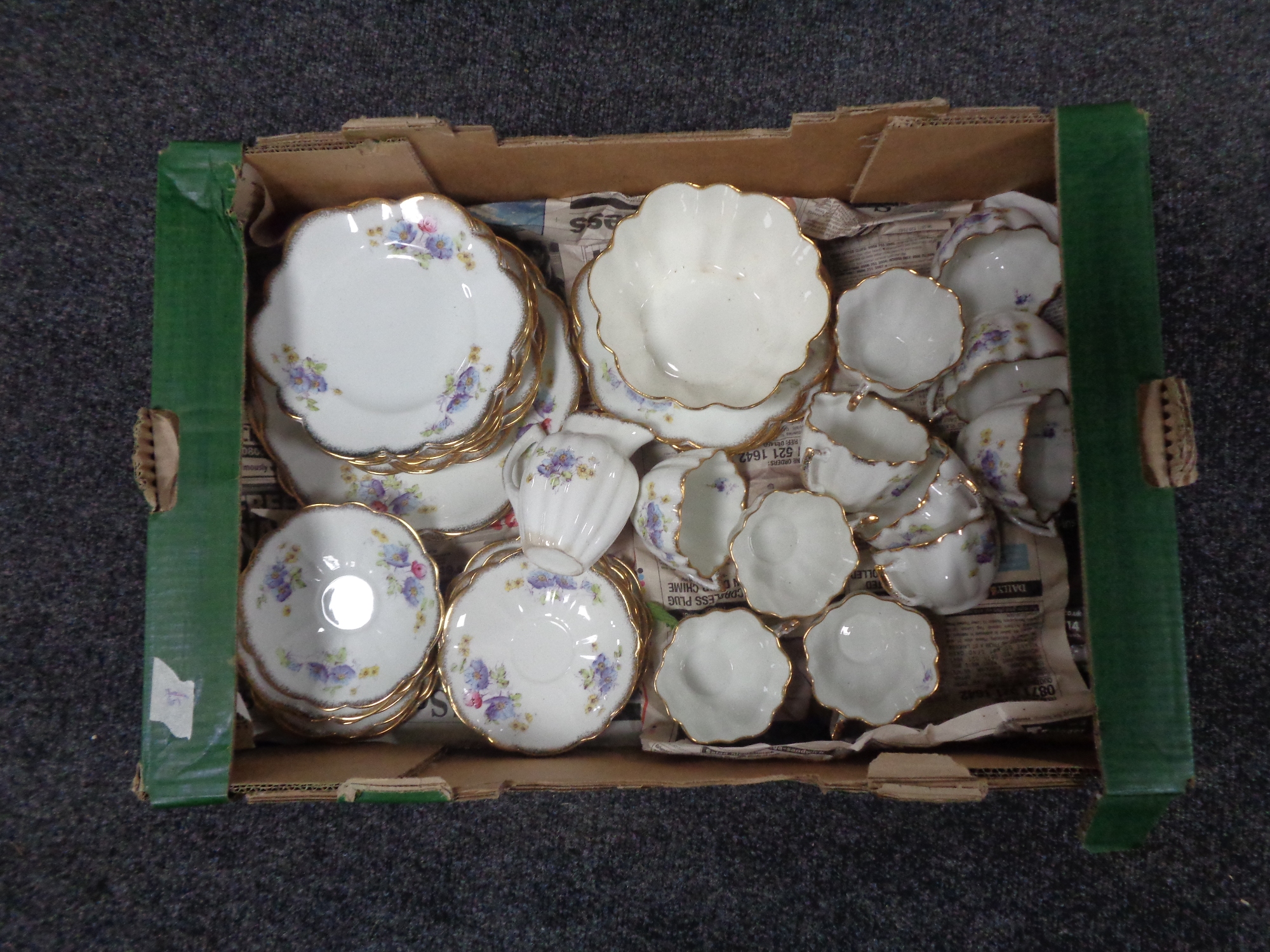 A tray containing a 28 piece gilt rimmed floral patterned china tea service.