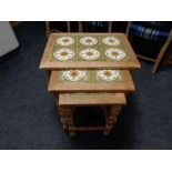 A nest of three blonde oak tile topped tables.