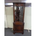 A mahogany corner display cabinet fitted with cupboards beneath