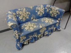 An early twentieth century settee in blue floral fabric