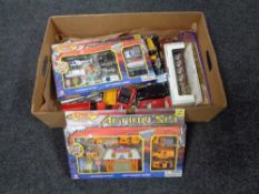 A box containing boxed and unboxed die cast vehicles and two boxed coronation carriages.