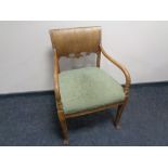 A 20th century scroll armchair upholstered in a green brocade fabric.