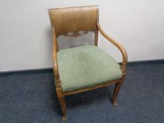 A 20th century scroll armchair upholstered in a green brocade fabric.