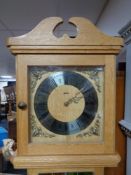 A blonde oak long cased clock by Agria with weights.