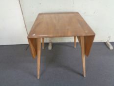 An Ercol elm and beech flap sided dining table
