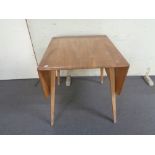 An Ercol elm and beech flap sided dining table