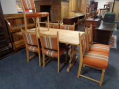 A blonde oak refectory dining table together with a set of seven dining chairs upholstered in an