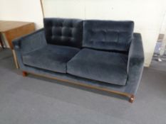 A John Lewis two seater settee upholstered in a blue suede like fabric.