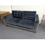 A John Lewis two seater settee upholstered in a blue suede like fabric.