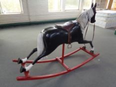 A large fibreglass rocking horse on wooden rockers