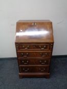 An inlaid mahogany writing bureau, fitted four drawers on bracket feet.