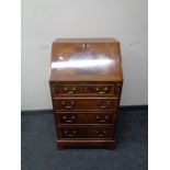 An inlaid mahogany writing bureau, fitted four drawers on bracket feet.