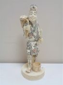 A Japanese carved bone okimono, figure with basket,