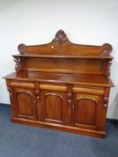 A Victorian style three drawer sideboard, fitted shelf above.