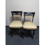 A pair of antique ebonised bedroom chairs upholstered in a Regency style striped fabric.
