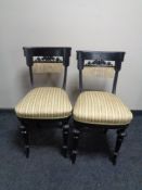 A pair of antique ebonised bedroom chairs upholstered in a Regency style striped fabric.