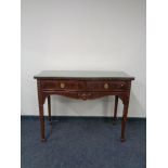 A Regency style two drawer serpentine fronted console table with glass top.