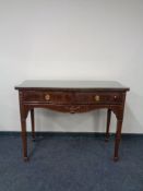 A Regency style two drawer serpentine fronted console table with glass top.