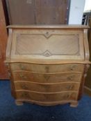 A 20th century oak serpentine fronted writing bureau, fitted four drawers.