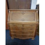 A 20th century oak serpentine fronted writing bureau, fitted four drawers.