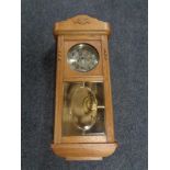 An early 20th century oak cased wall clock with silver dial.